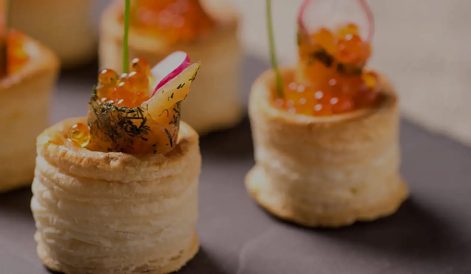 Gotham catering and events Homemade puff pastry bouche with salmon gravlax, salmon roe , radish and chive